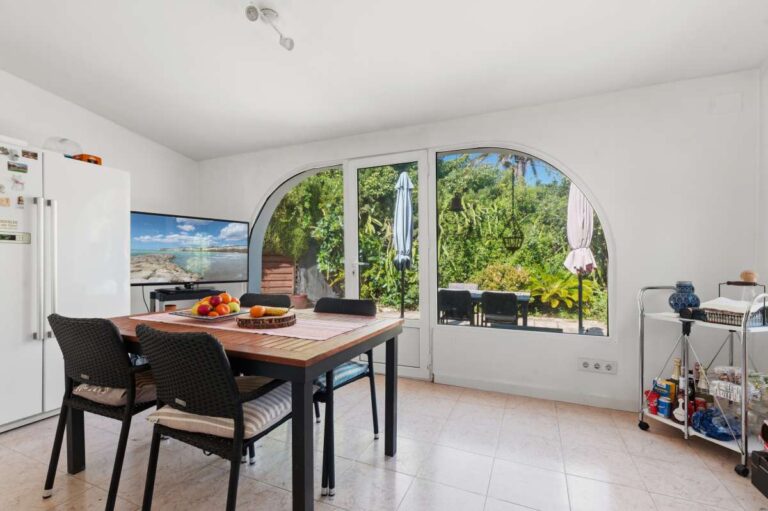 Dining area inside a Mediterranean villa in Benissa Costa with arched windows, table seating and direct terrace access