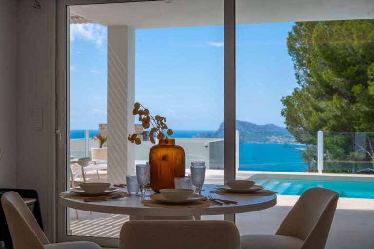 Dining area inside a modern villa in Altea Hills with terrace access, pool views and panoramic Mediterranean Sea views