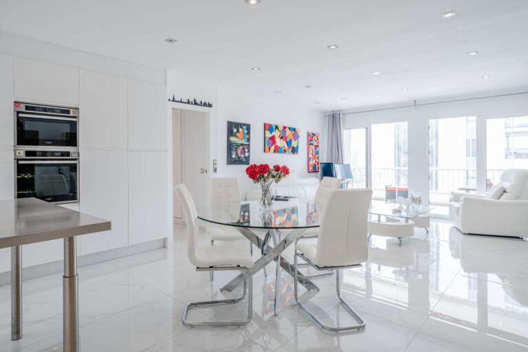 Dining area inside a renovated apartment in Arenal-Bol, Calpe with open-plan layout, natural light and modern white interior