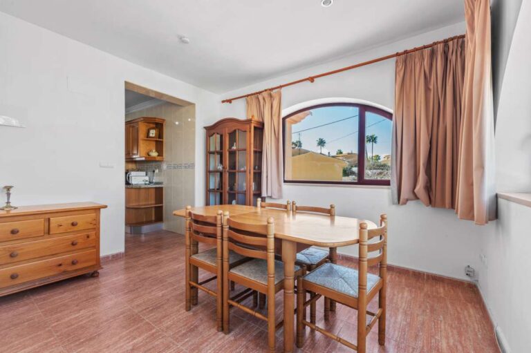 Dining area with arched window and open views inside a guest apartment at a spacious villa with Peñón de Ifach views in Calpe.