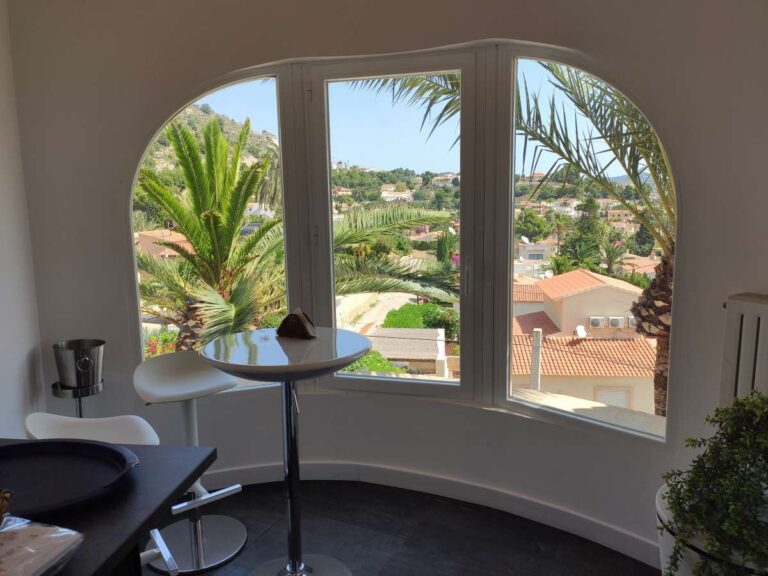 Dining area with arched windows and views from a refurbished villa with three independent apartments in Canuta, Calpe.