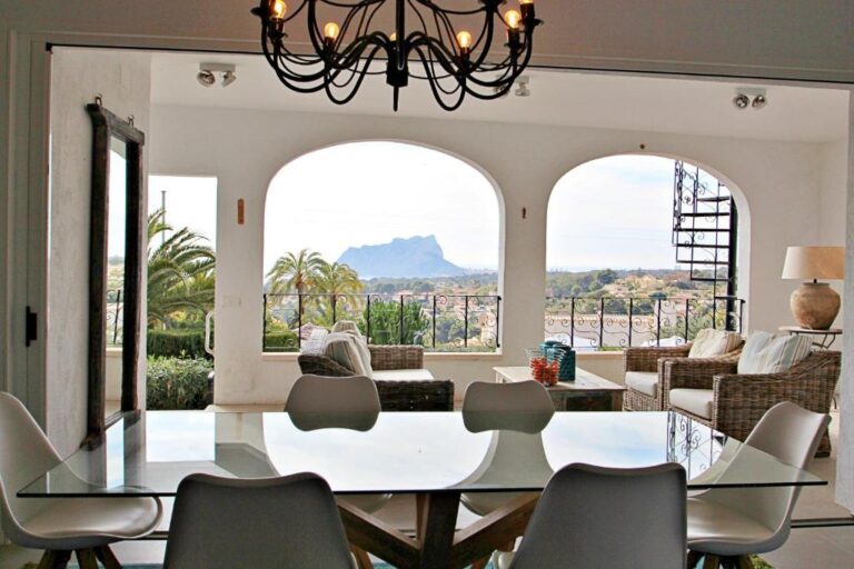 Dining area with arched windows and views towards the Peñón de Ifach in Moraira villa