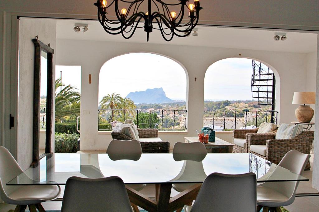 Dining area with arched windows and views towards the Peñón de Ifach in Moraira villa