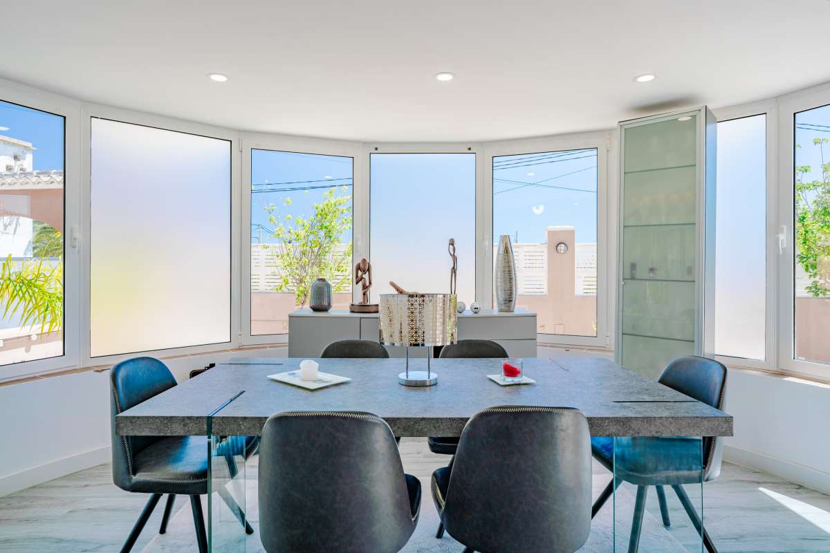 Dining area with large windows and modern light-toned interior inside a renovated Mediterranean villa in La Cometa, Calpe.