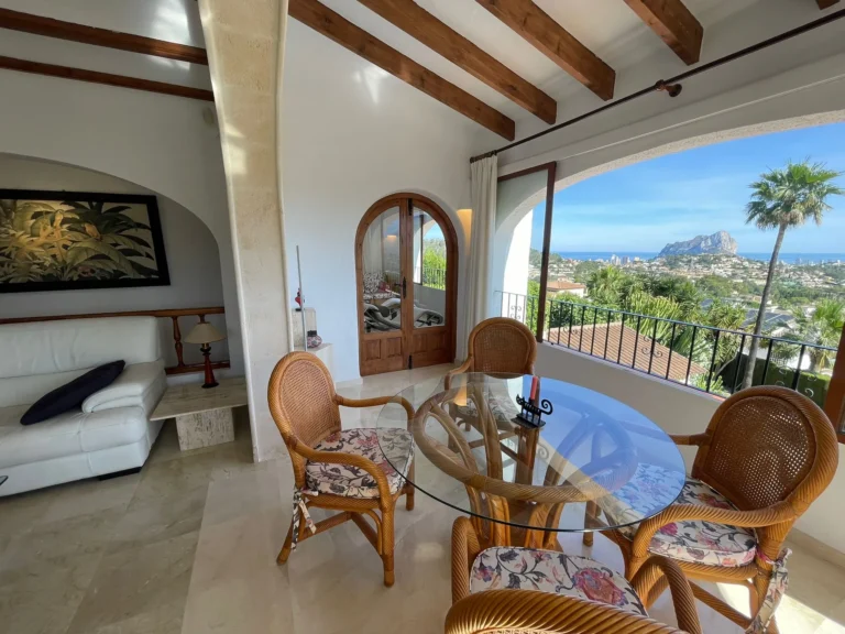 Dining area with sea views and adjoining lounge inside a villa in Calpe.