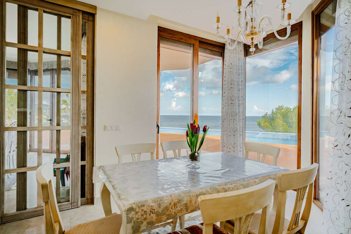 Dining area with sea views and natural light inside a frontline villa in Les Bassetes, Benissa Coast.