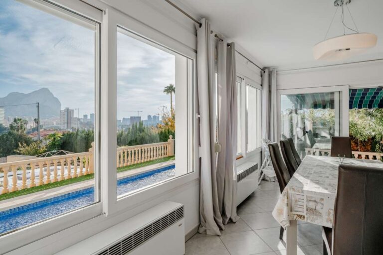 Dining room inside a villa in Calpe with views over the private pool towards the Peñón de Ifach