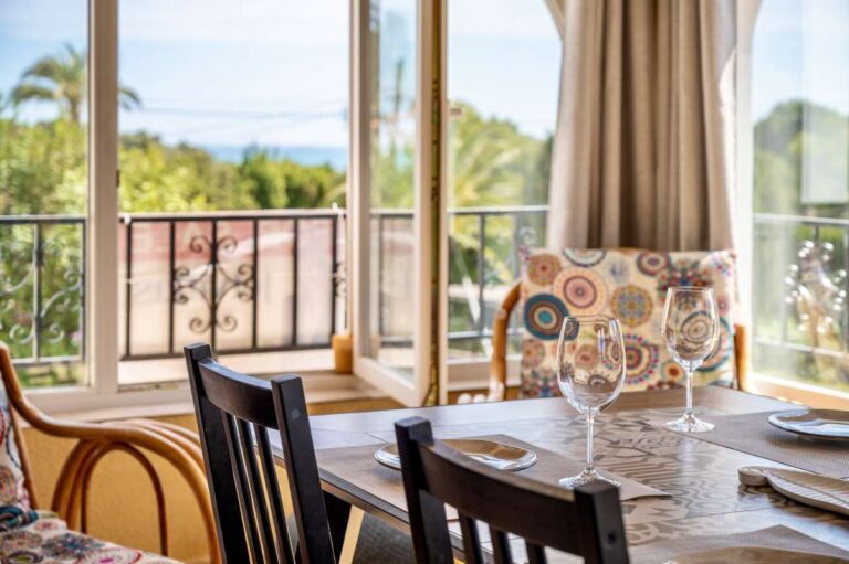 Dining table inside a charming Benissa Coast villa with large windows, garden views, natural light and Mediterranean interior details