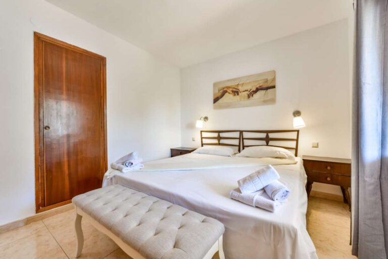 Double bedroom inside a charming Benissa Coast villa with wooden wardrobe, bedside lighting, bright interior and neutral bedroom styling