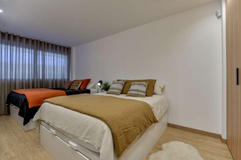 Double bedroom inside a luxury frontline beach duplex in Mascarat, Altea with warm bedding, bedside lighting and modern neutral finish