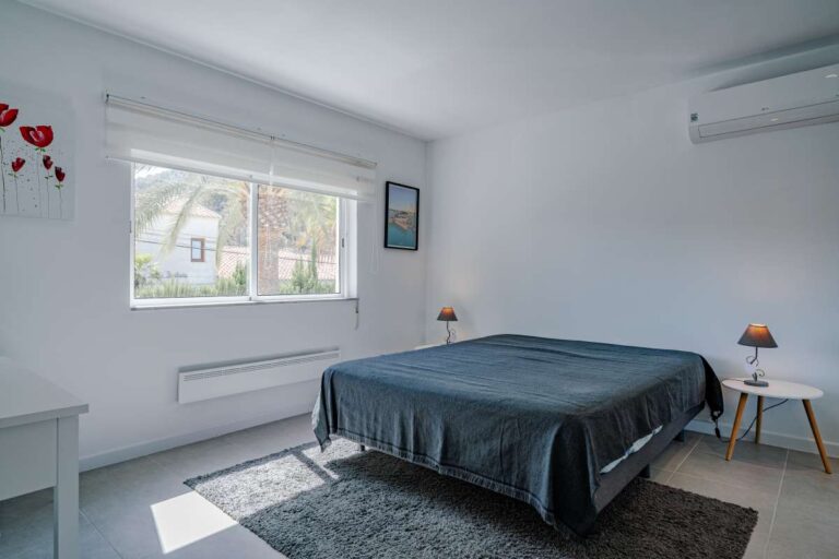 Double bedroom inside a modern villa in Calpe with large window, air conditioning and bright interior space