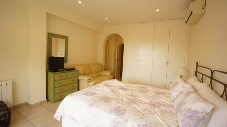 Double bedroom with air conditioning and fitted storage inside a villa near La Fustera beach.