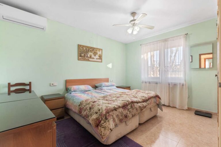 Double bedroom with air conditioning and natural light inside a single-level villa in Calpe close to beaches and amenities.