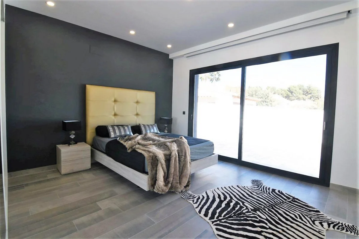 Double bedroom with large sliding doors and terrace access in modern Calpe villa