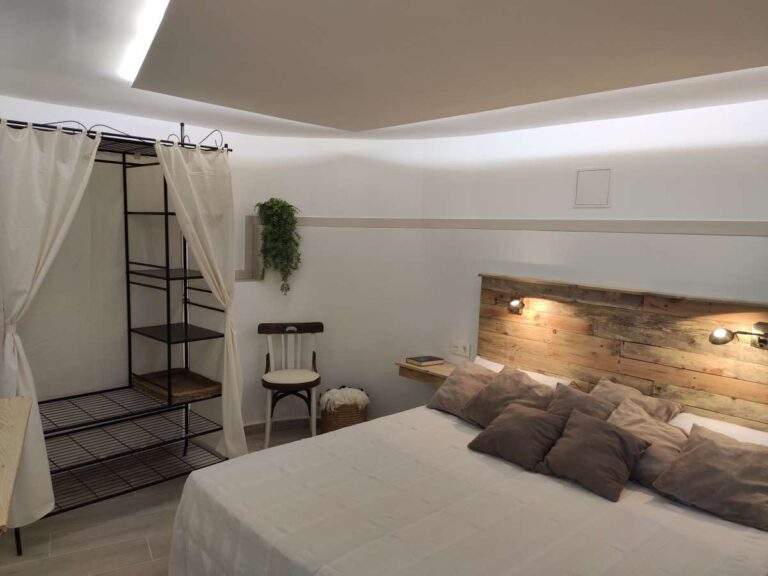 Double bedroom with modern lighting, neutral finishes and staircase access inside a refurbished villa in Canuta, Calpe.