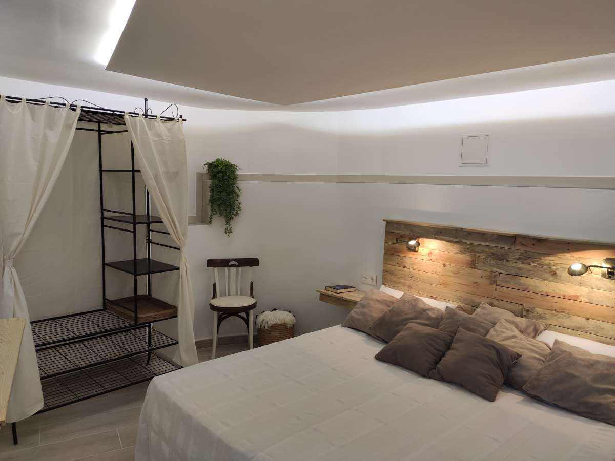 Double bedroom with modern lighting, neutral finishes and staircase access inside a refurbished villa in Canuta, Calpe.
