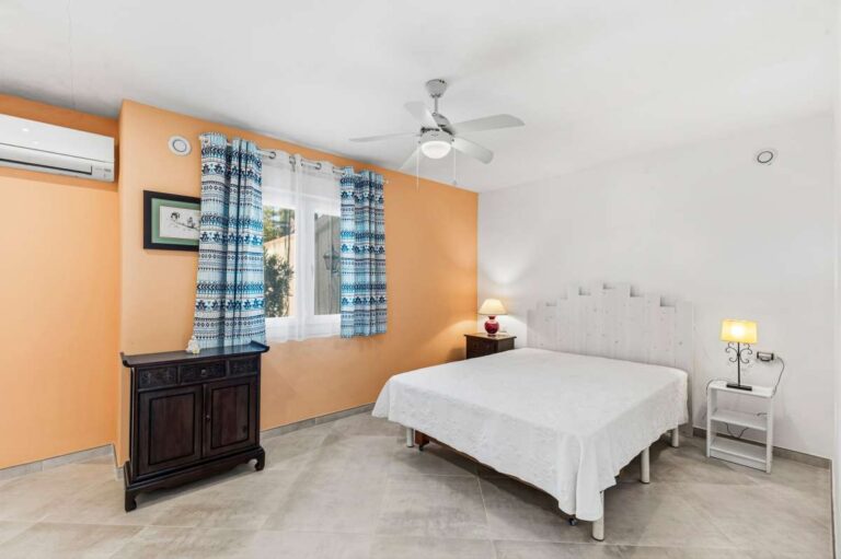 Double bedroom with natural light and ceiling fan inside a contemporary villa in a peaceful residential area of Calpe.
