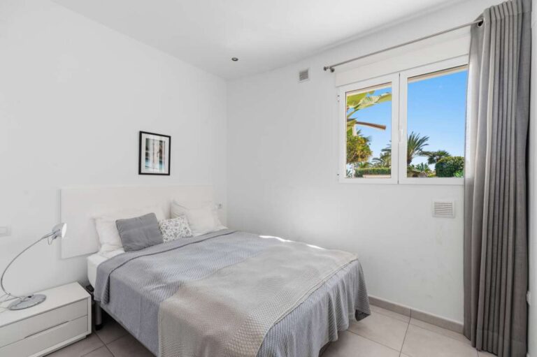 Double bedroom with natural light and fitted storage inside a villa in Calpe.