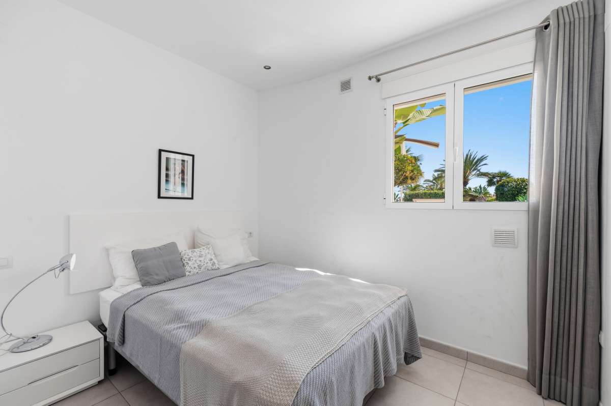 Double bedroom with natural light and fitted storage inside a villa in Calpe.