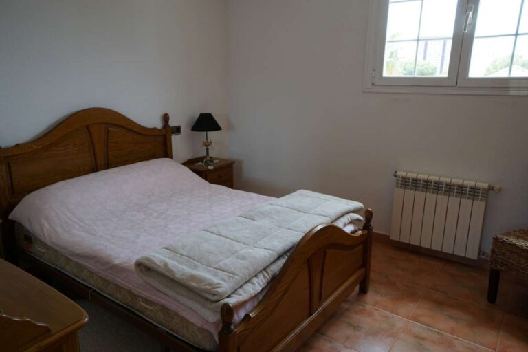 Double bedroom with traditional wooden furniture inside a Mediterranean villa in Calpe.