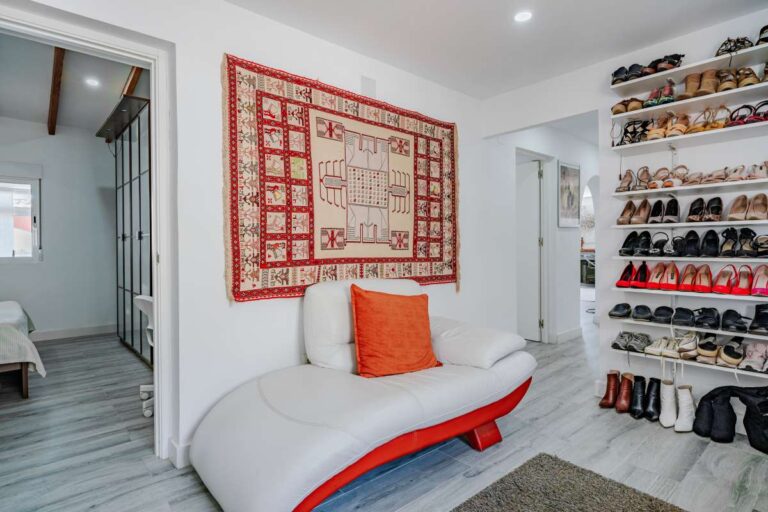 Dressing room lounge area with seating and storage inside a renovated Mediterranean villa in La Cometa, Calpe.