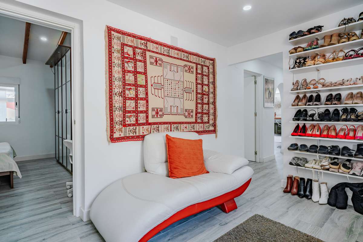 Dressing room lounge area with seating and storage inside a renovated Mediterranean villa in La Cometa, Calpe.