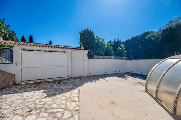 Driveway and covered pool exterior at a Mediterranean villa in Benissa Costa near Cala Baladrar with stone paving and private entrance gate