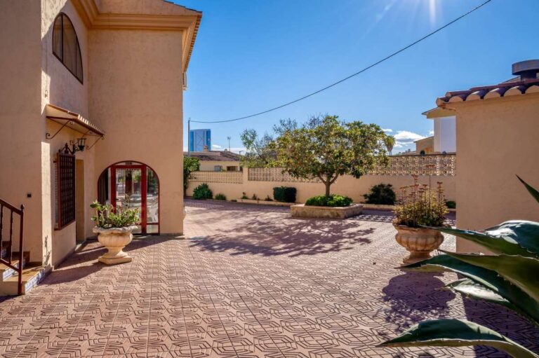 Driveway courtyard with parking area and exterior access at a spacious villa with guest apartments in Calpe.