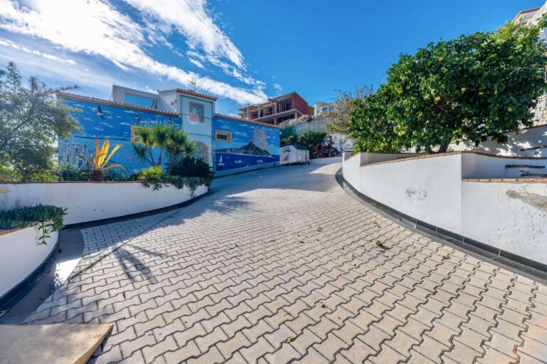 Driveway entrance to a large private villa in Calpe with sea views, landscaped walls and spacious parking area
