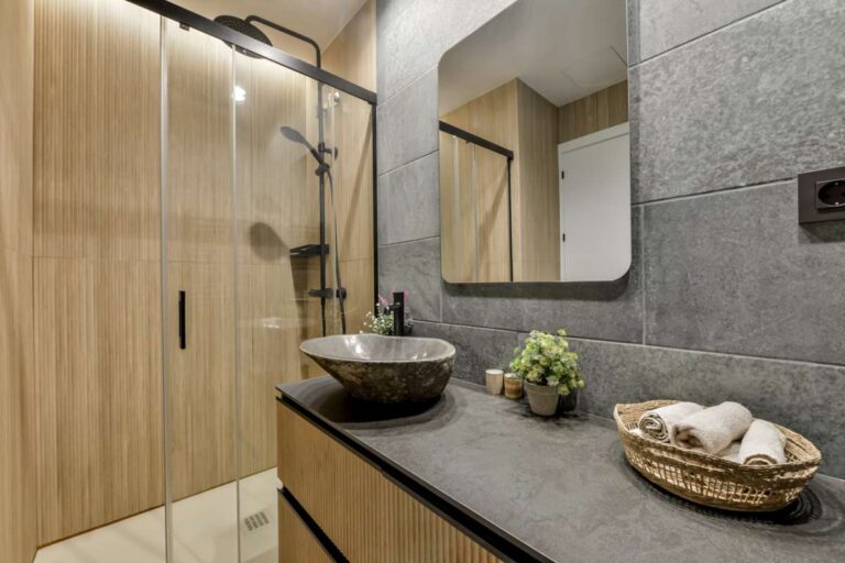 En-suite bathroom inside a luxury frontline beach duplex in Mascarat, Altea with walk-in shower, vanity unit, mirror and modern grey tiled finish