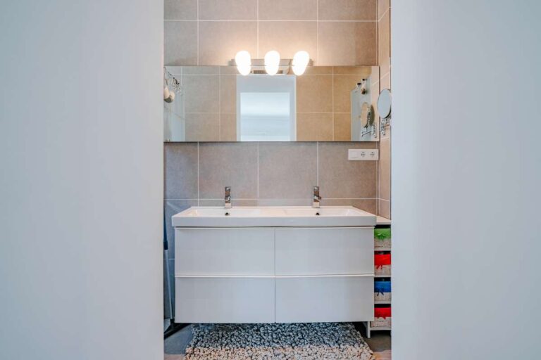 En-suite bathroom inside a modern villa in Calpe with vanity unit, mirror and tiled finish