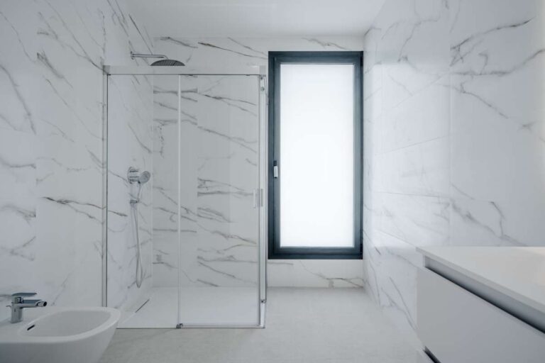 En-suite bathroom inside a modern villa in La Calalga, Calpe with walk-in shower, marble-effect tiling and window natural light