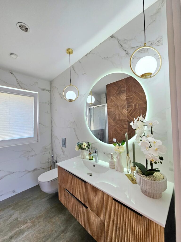 En-suite bathroom inside a modern villa near Les Bassetes, Calpe with vanity unit, round mirror, walk-in shower and modern finish