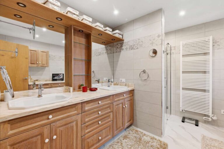 En-suite bathroom inside a premium coastal villa on the Benissa Costa with wooden vanity unit, walk-in shower, towel radiator and bright tiled finish
