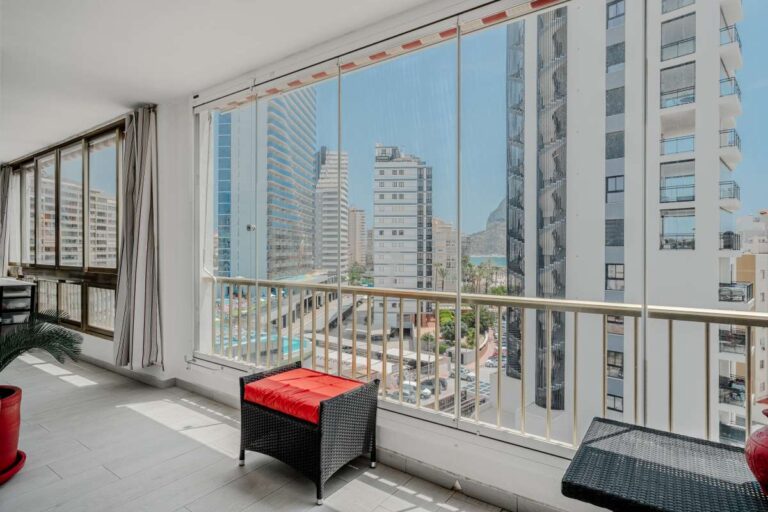 Enclosed terrace inside a renovated apartment by Arenal-Bol Beach in Calpe with town views, natural light and seating space
