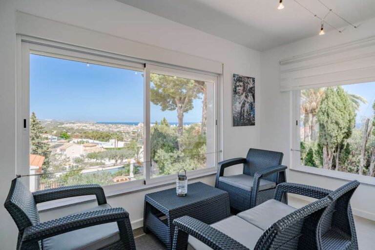 Enclosed terrace sitting area in a modern Calpe villa with large windows and open views