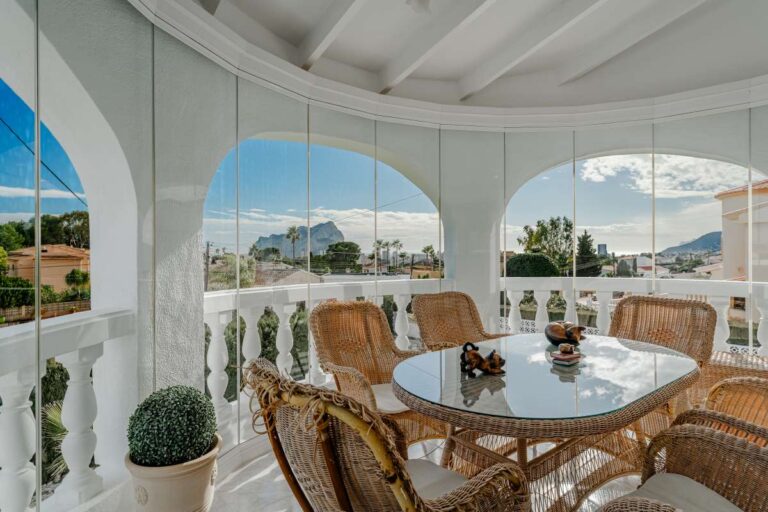 Enclosed terrace with dining area and views towards the Peñón de Ifach at a Mediterranean villa in Calpe.