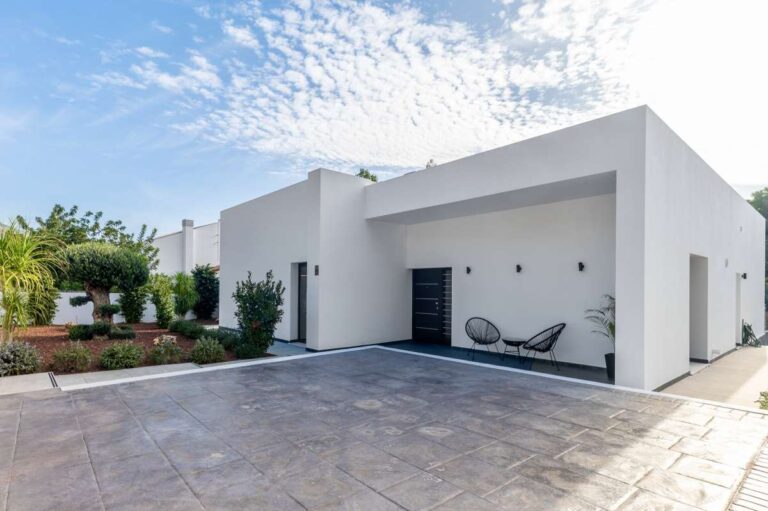 Entrance and driveway at a single-level modern villa in Santa Clara, Altea with white exterior, private parking area and covered entrance