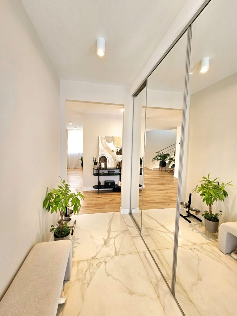 Entrance hall inside a modern villa near Les Bassetes, Calpe with mirrored storage, marble-style floor and access to the living area