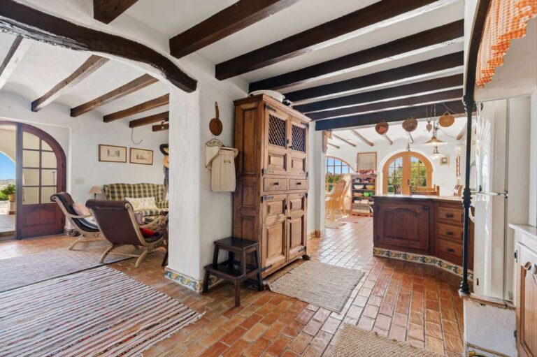 Entrance hall inside a traditional Spanish finca near Moraira with wooden doors, tiled floor, beamed ceiling and access to the living areas