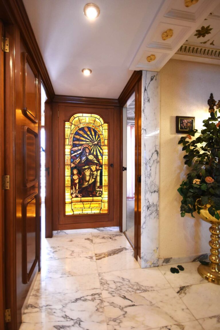 Entrance hall with stained glass door, marble flooring and decorative details inside a frontline double penthouse in Calpe.