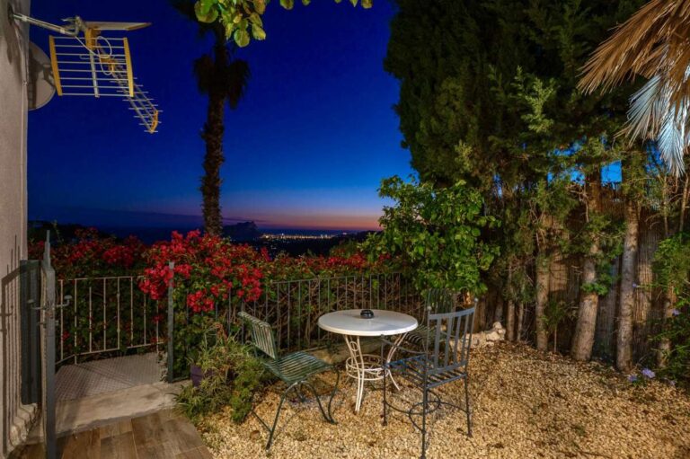 Evening garden terrace at a panoramic sea view villa in Benissa with outdoor table, Mediterranean planting and views towards Calpe