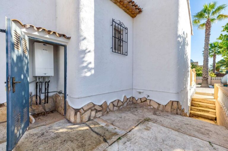 Exterior entrance area at a single-level villa in Calpe with Mediterranean-style details and garden access.