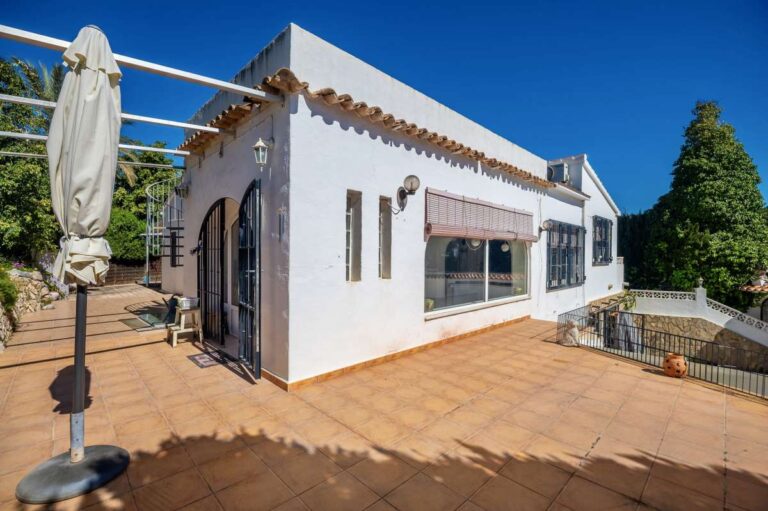 Exterior of a Mediterranean villa in Benissa Costa near Cala Baladrar with white façade, arched windows and spacious terrace area
