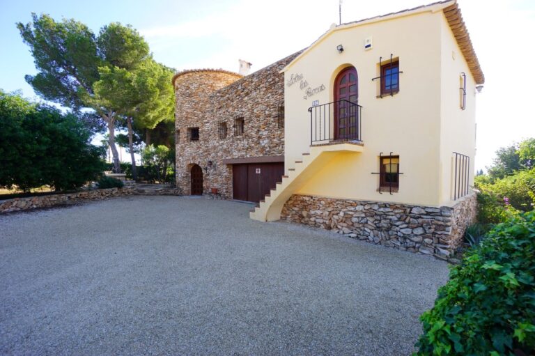 Exterior of a Mediterranean villa in Calpe with stone detailing, private driveway, garage access and traditional architectural character
