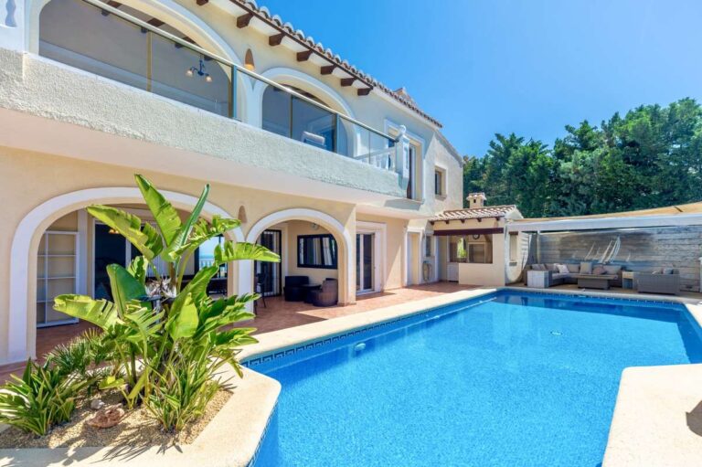Exterior of an elegant Mediterranean villa in Altea Hills with private swimming pool, arched terrace, tropical planting and outdoor living areas