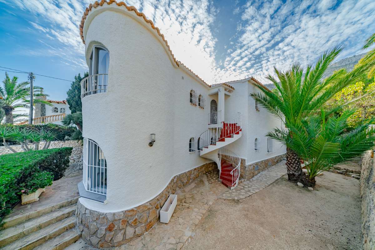 Exterior view of a Mediterranean villa with garden steps, arched balcony and coastal surroundings in Maryvilla, Calpe.