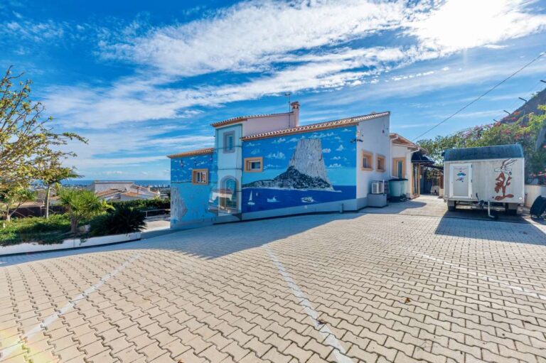 Exterior view of a private villa in Calpe with large parking area, sea views and Mediterranean surroundings