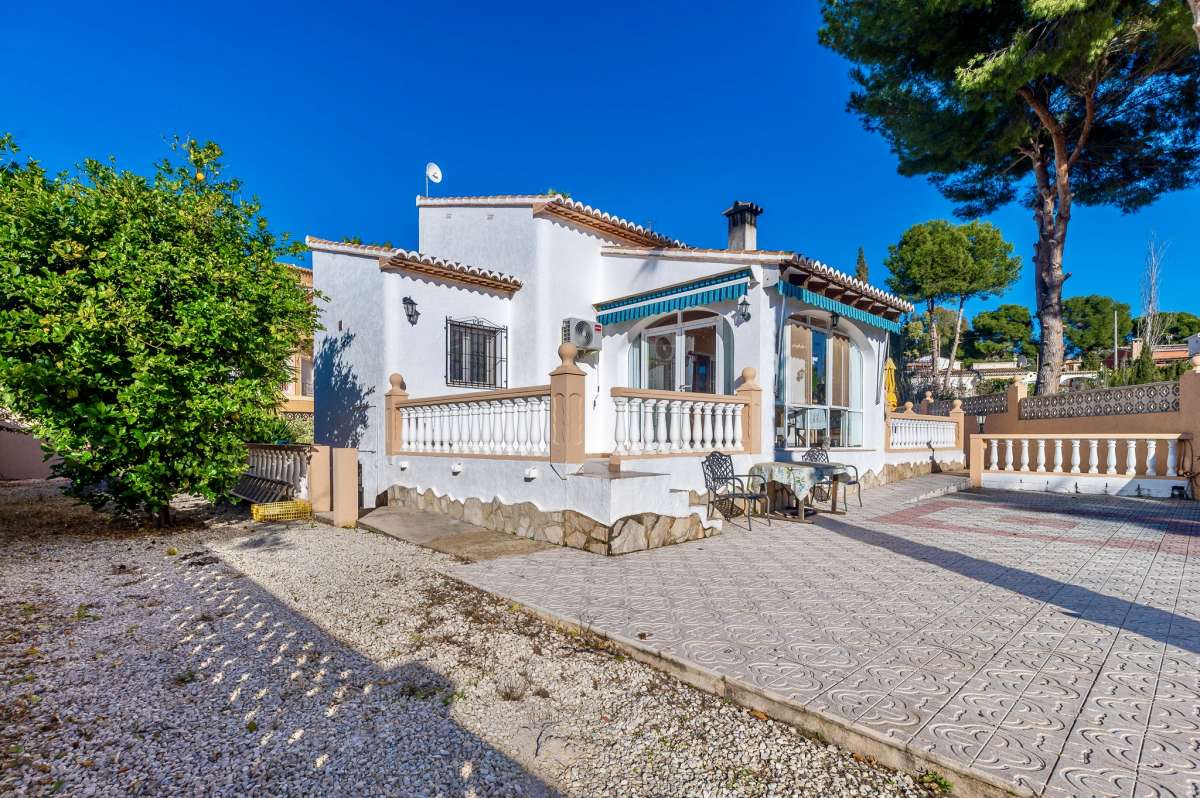 Exterior view of a single-level villa in Calpe with driveway, garden area and covered naya.