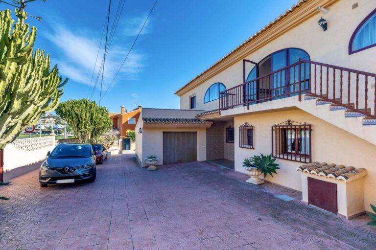 Exterior view of a spacious villa in Calpe with driveway, garage and parking area.
